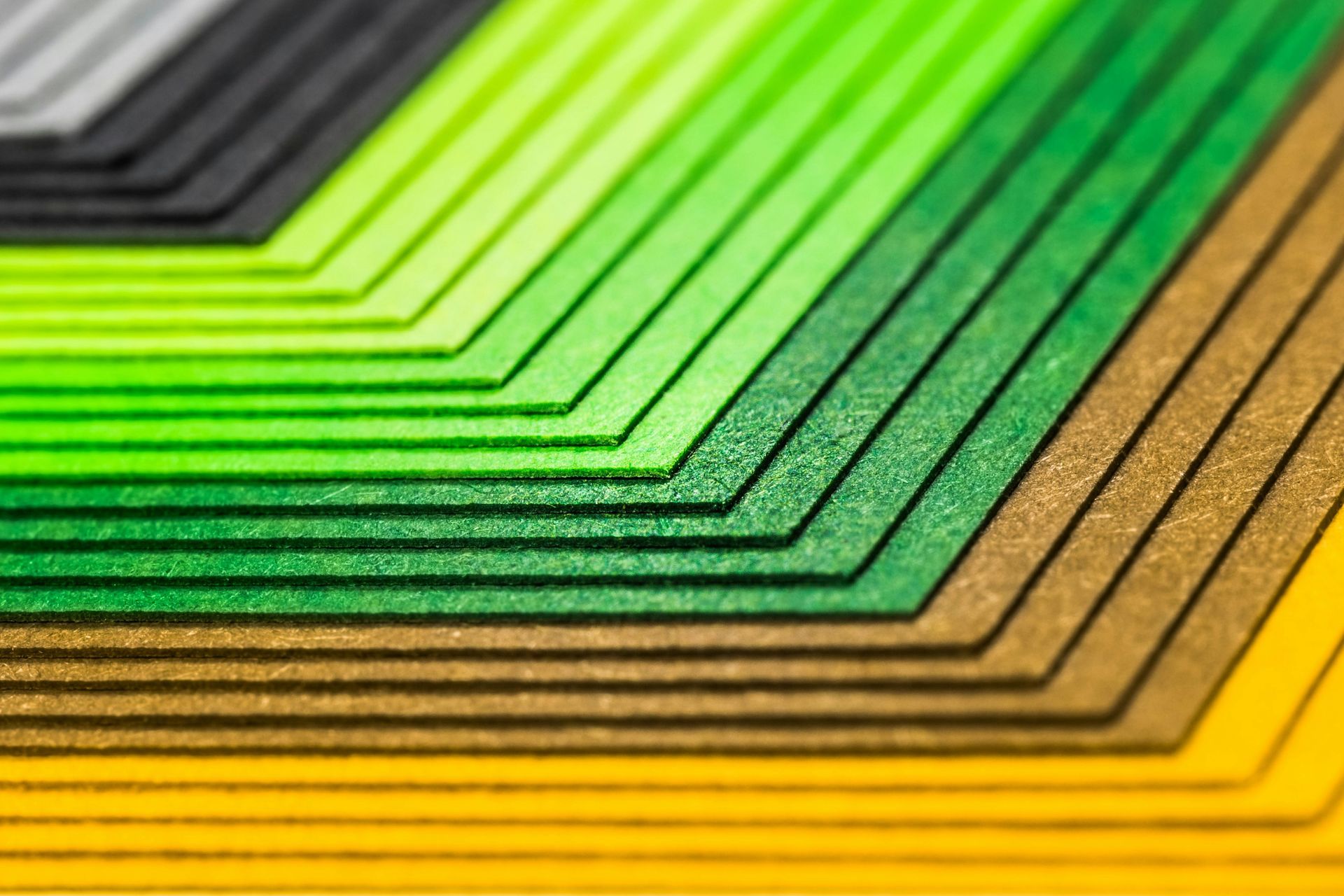 Stacked, layered geometric shapes in a gradient of colors from yellow to black.