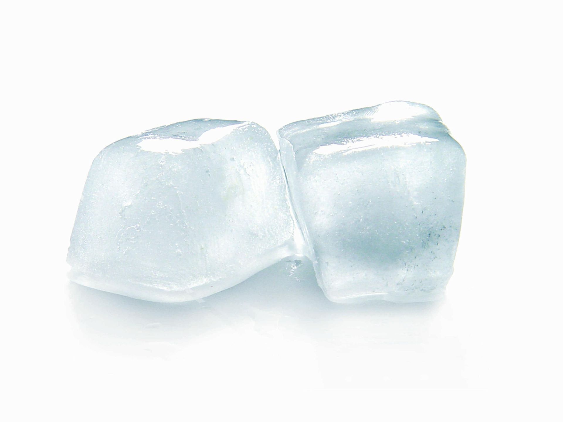 Two ice cubes are sitting next to each other on a white surface.