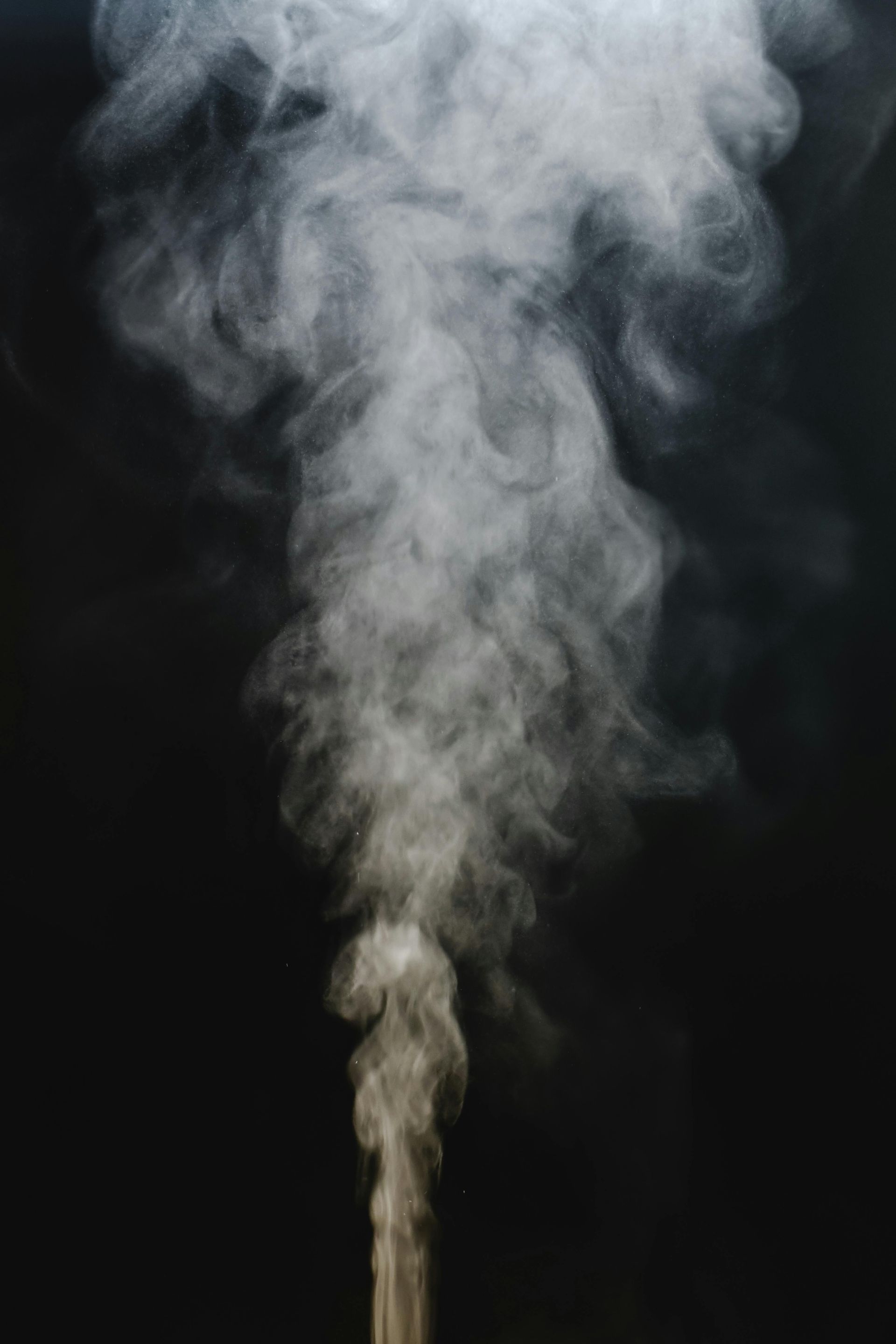 vapour is coming out of a pipe on a black background.