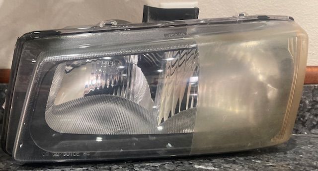 Close-up of a car headlight assembly with a clear lens and reflective housing