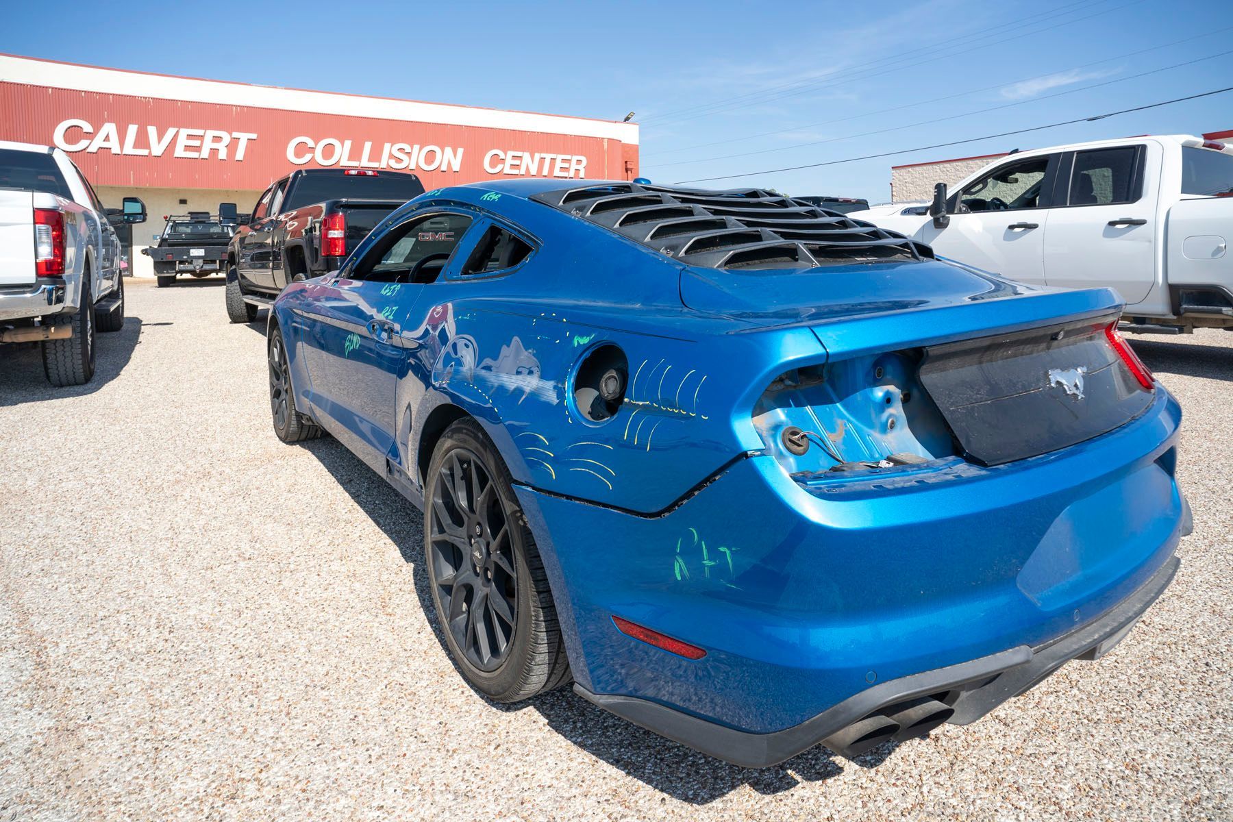 Blue Ford Mustang parked outside Calvert Collision Centre on a sunny day
