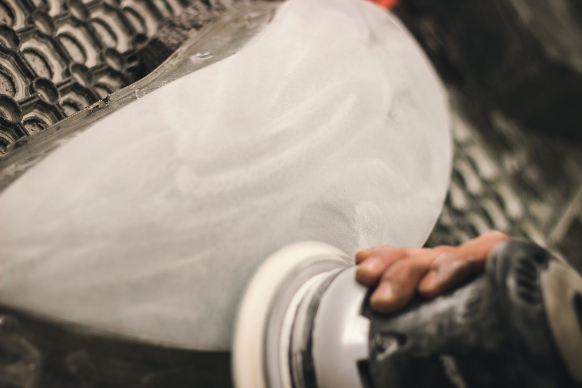 Hand polishing a white ceramic bowl on a potter’s wheel with a cloth