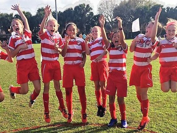 Girls soccer team celebrating for Space Coast United Soccer