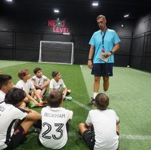 Soccer coach talking to a group of young players for Space Coast United Soccer