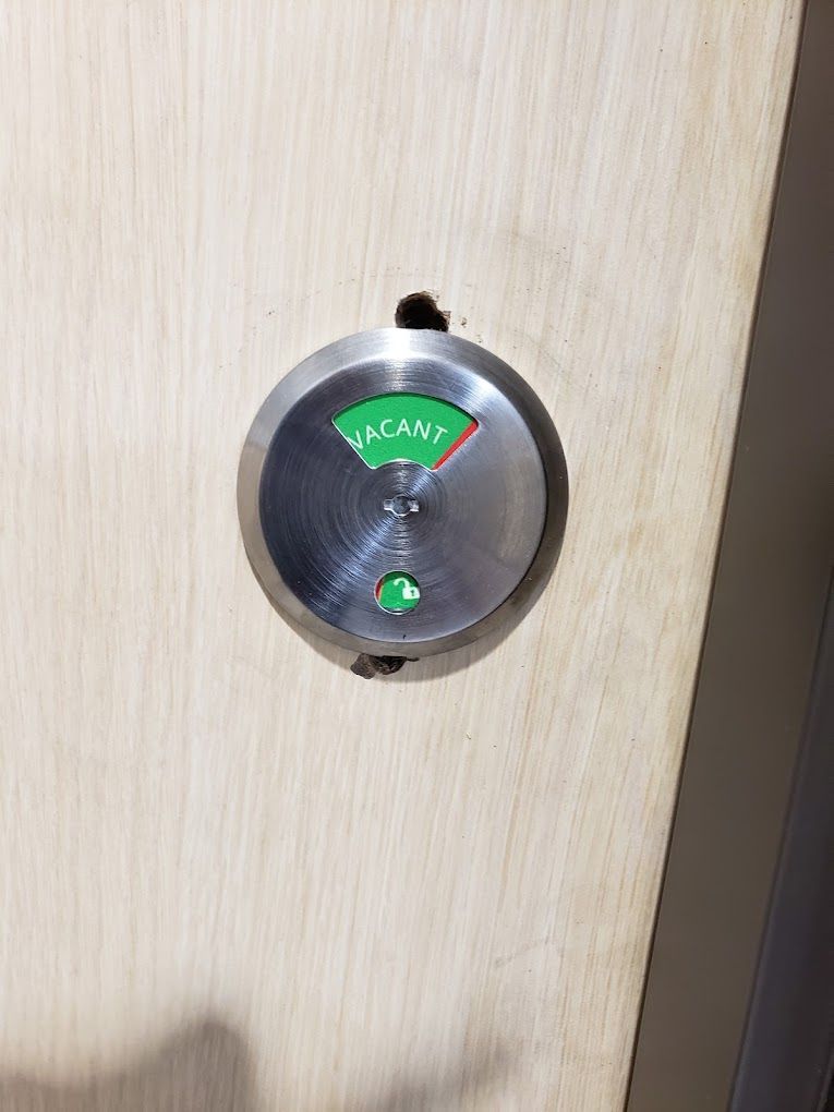 A close up of a door lock on a wooden door.