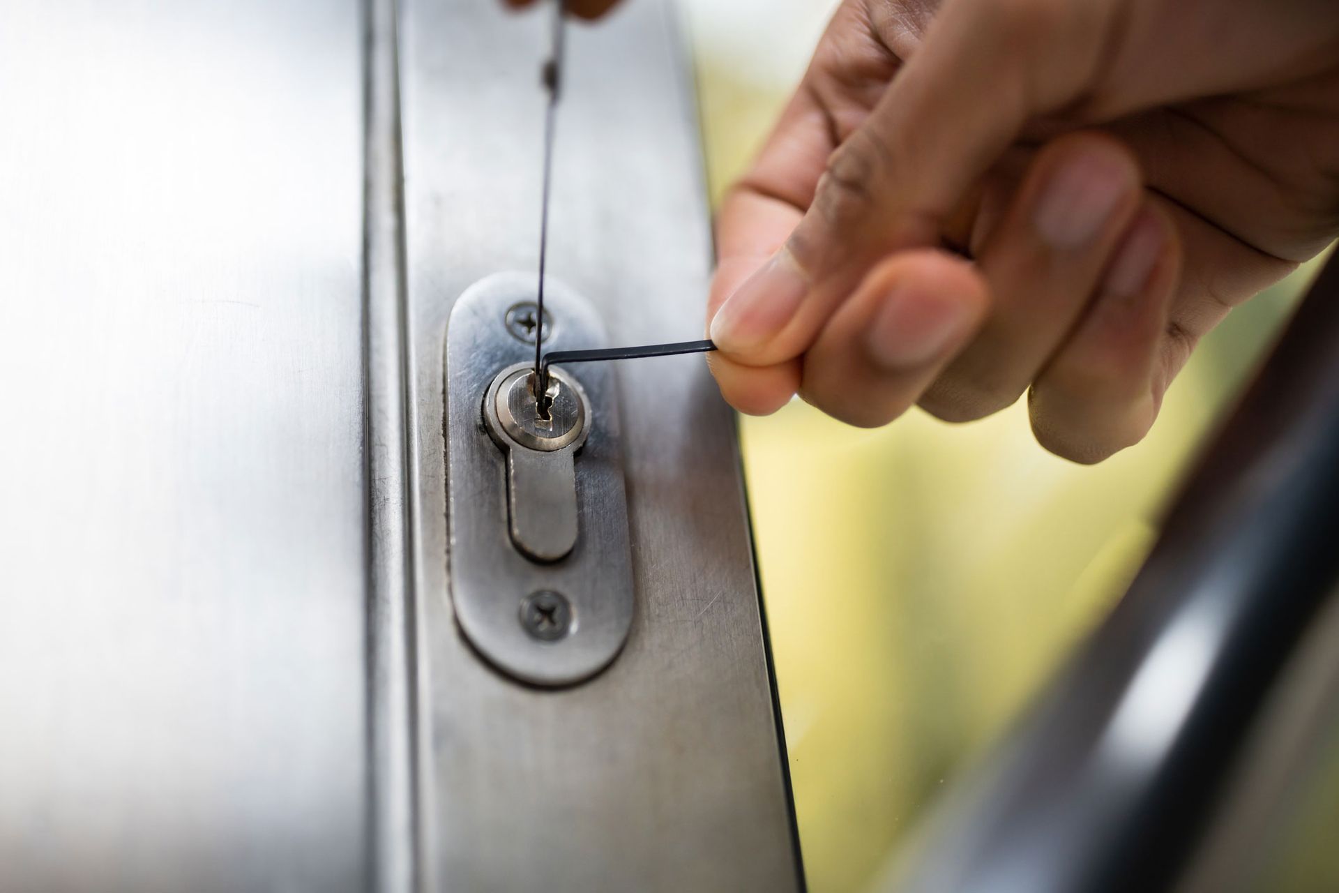 A person is using a screwdriver to open a door lock.