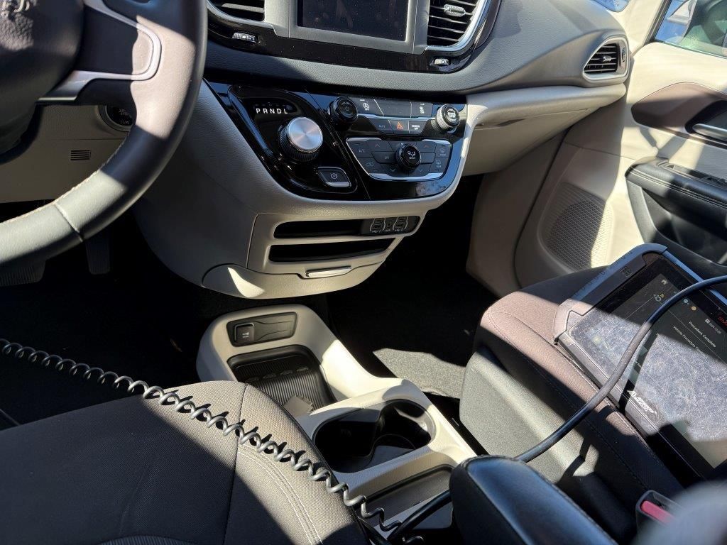The inside of a car with a phone in the center console