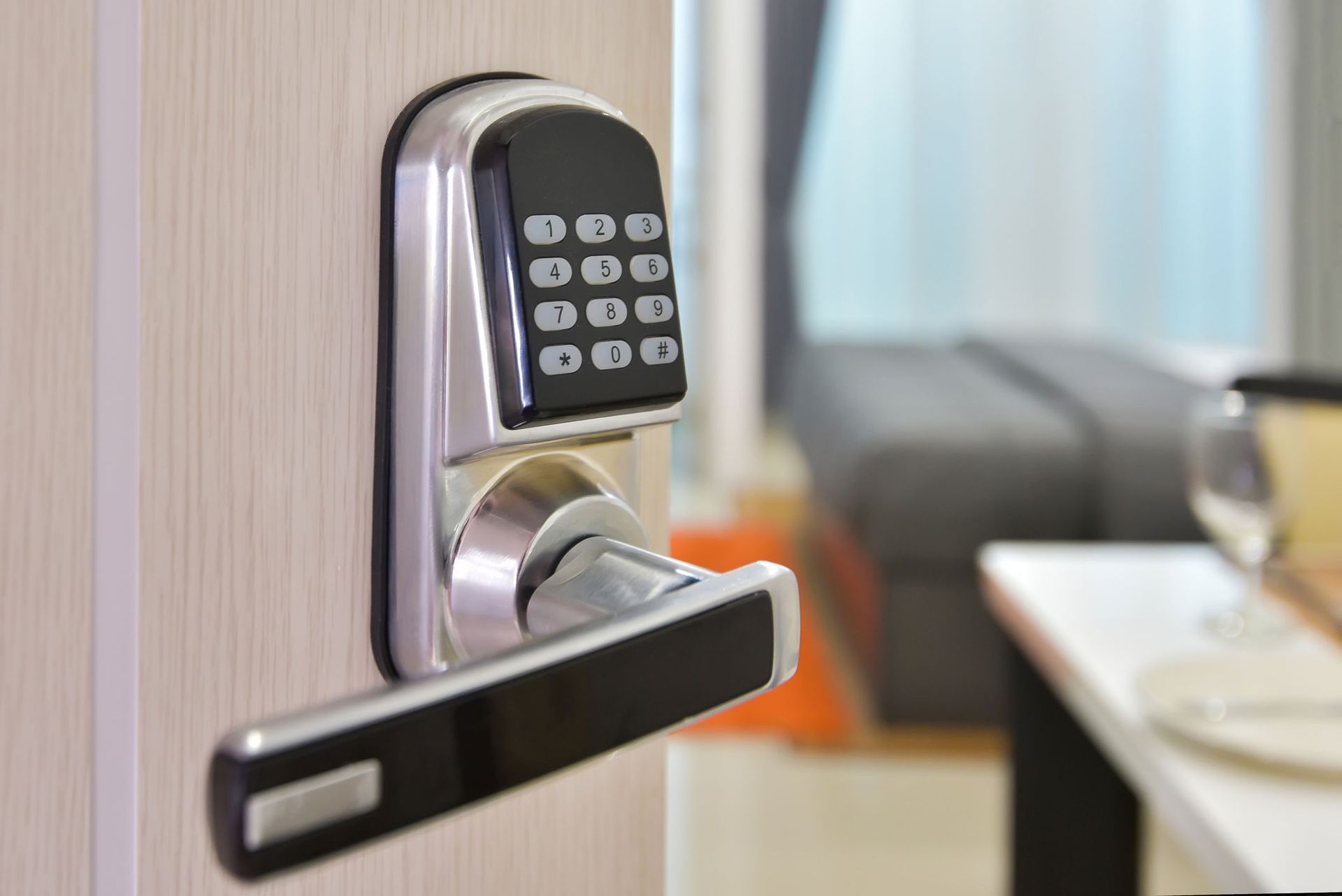 A close up of a digital door lock on a door in a living room.