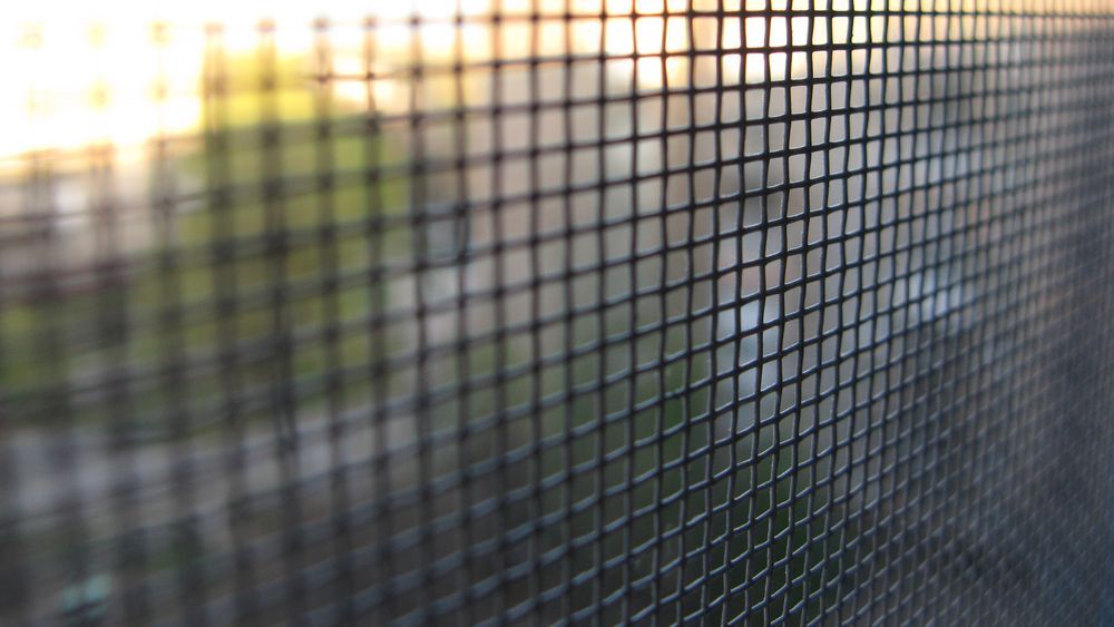 Close-up View of a Dark Window Screen Mesh With a Blurry — Australian Flyscreens & Security Doors in Toronto, NSW