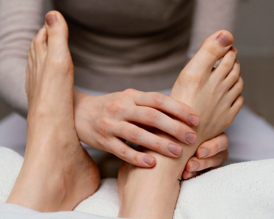 A woman is giving a foot massage to another woman for peripheral neuropathy.