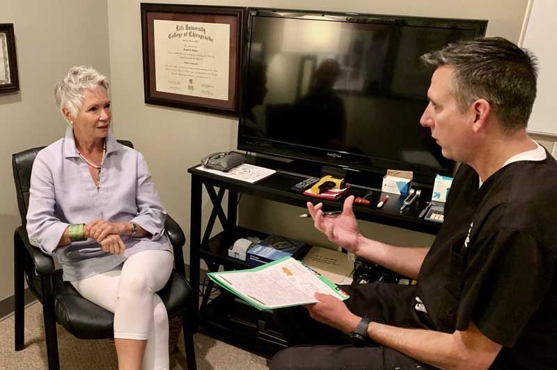 A man and a woman are sitting in a room talking to each other.