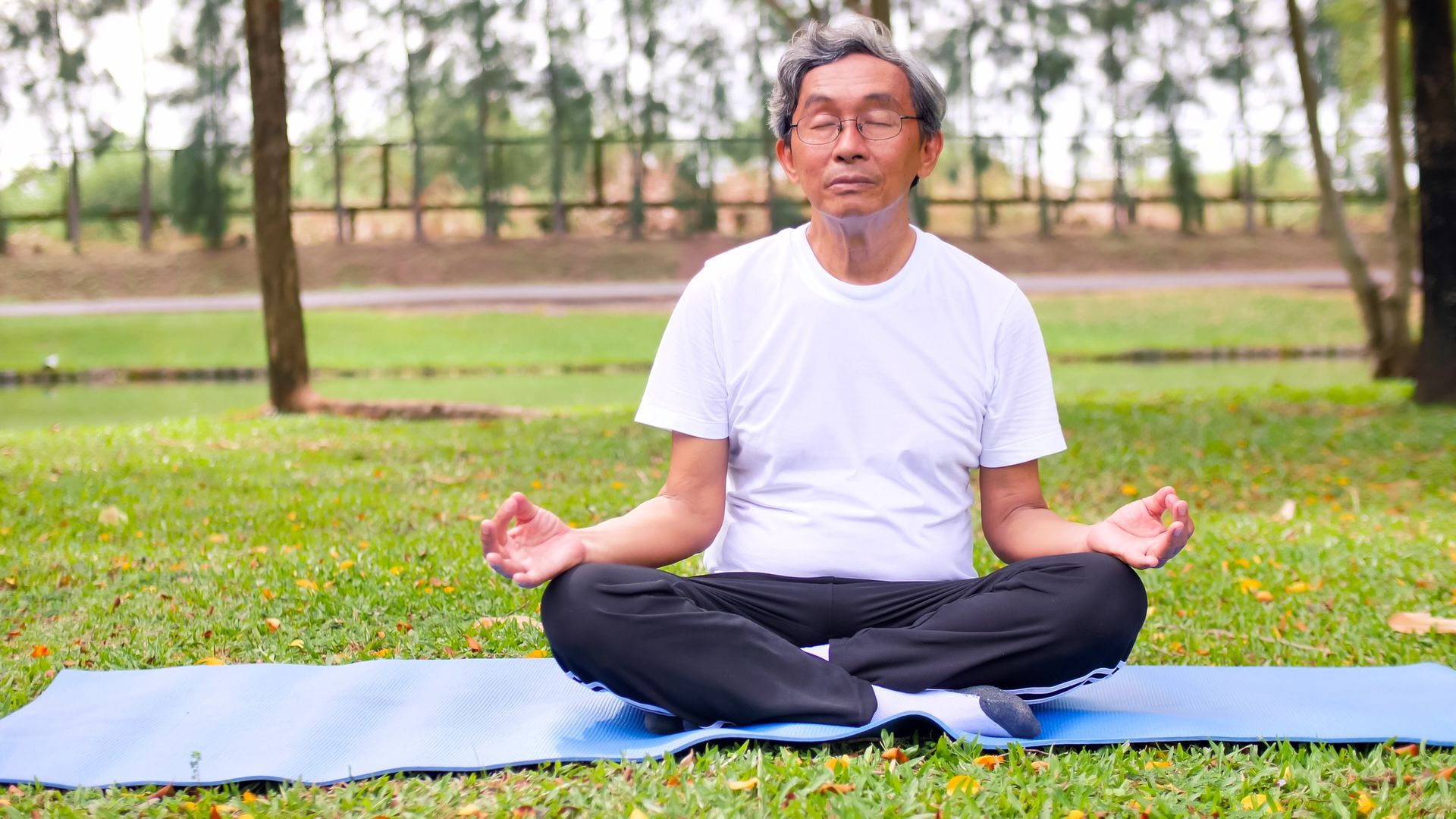 man doing yoga in park