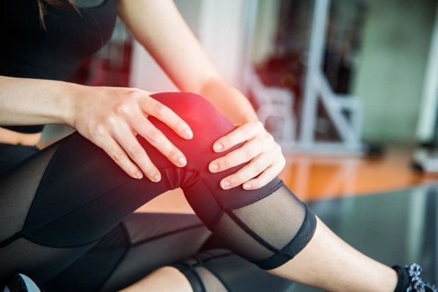 woman holding knee in pain