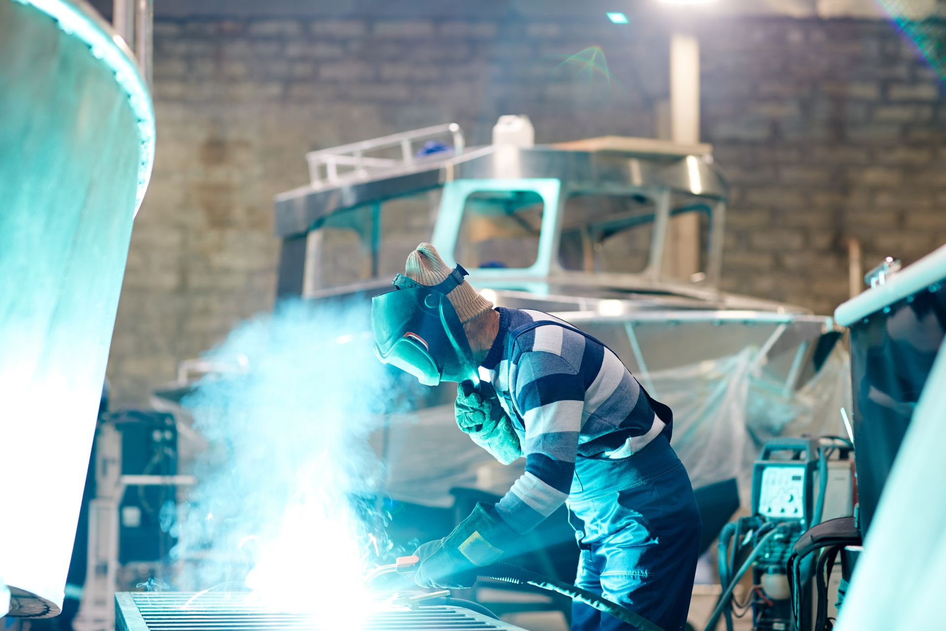 Soudeur travaillant avec des étincelles bleues vives dans un atelier industriel