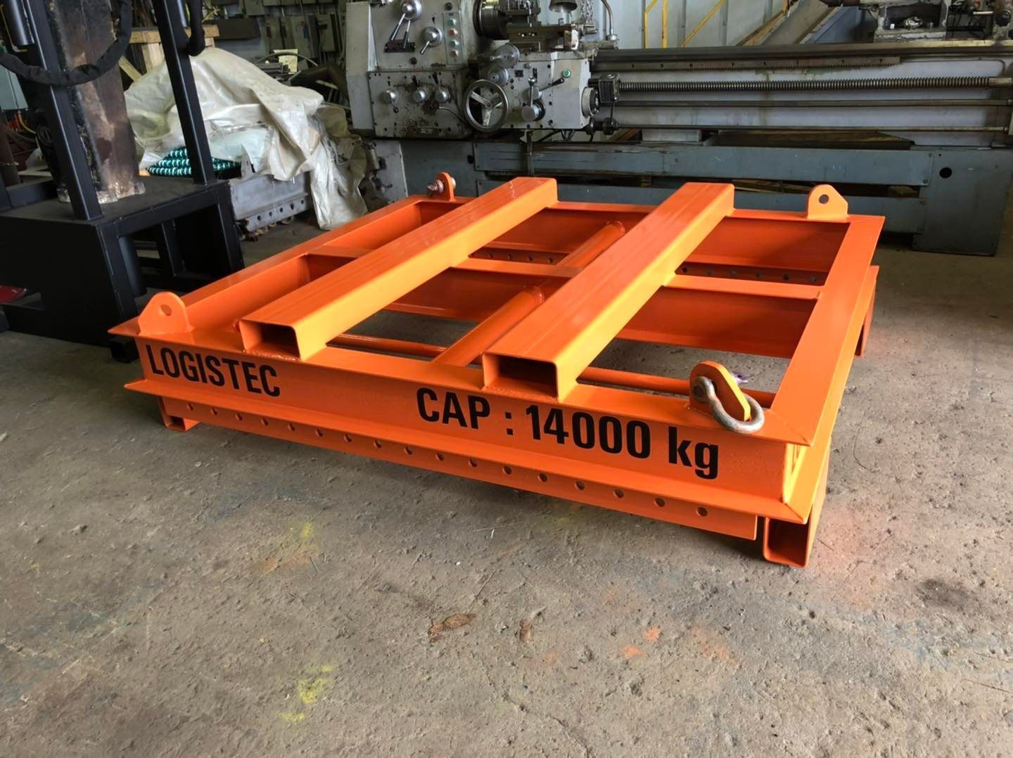 Cadre de levage en acier orange portant l'inscription « CAP : 14 000 kg » dans un atelier industriel
