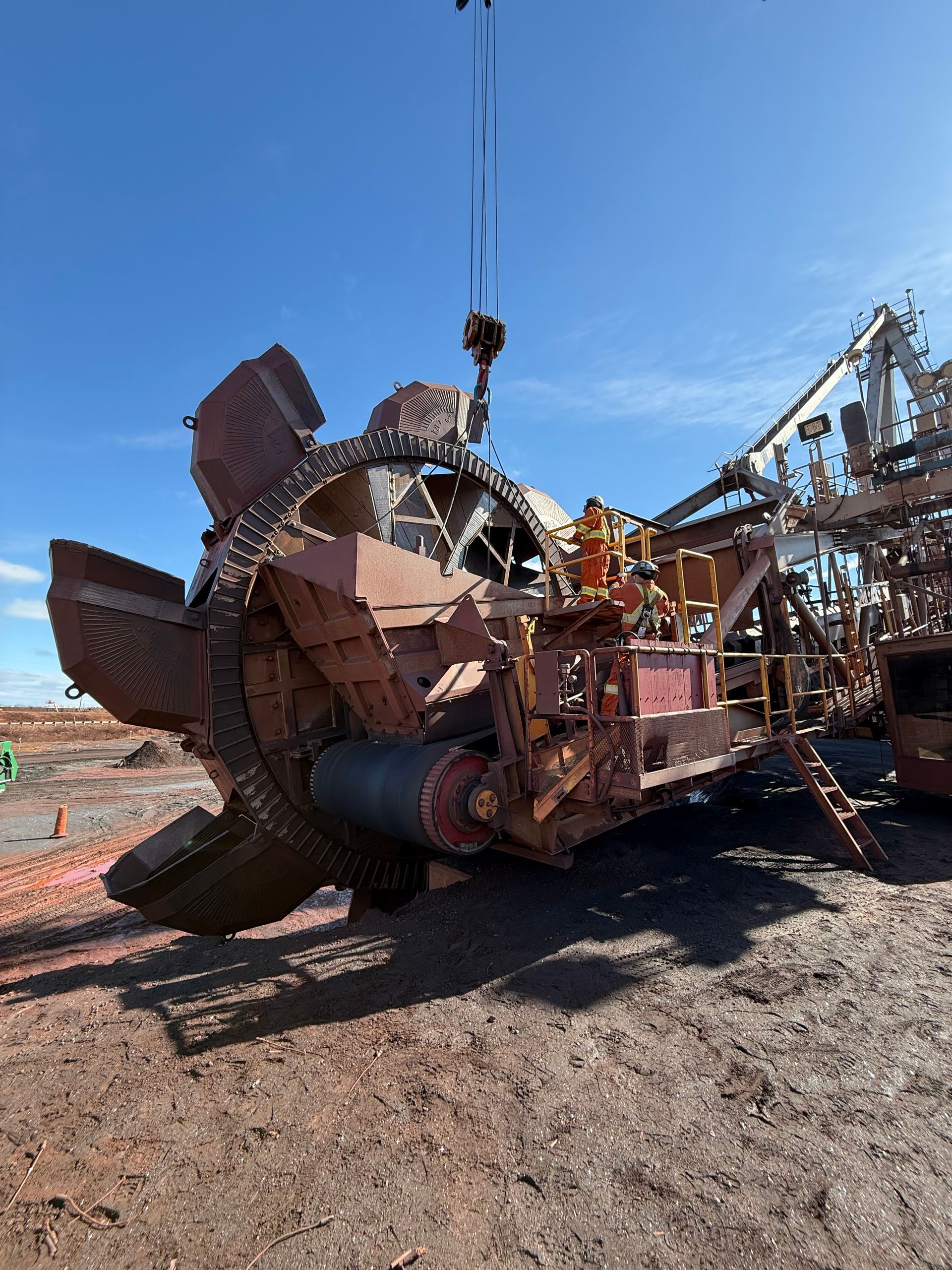 Machines industrielles rouillées sur un terrain vague sous un ciel bleu azur