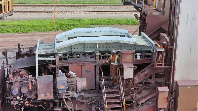 Machines industrielles rouillées aux panneaux incurvés bleu pâle le long des voies ferrées