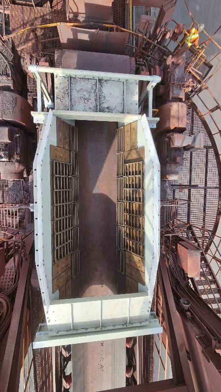 Construction d'un tunnel industriel avec puits en béton, échafaudages métalliques et échelles.