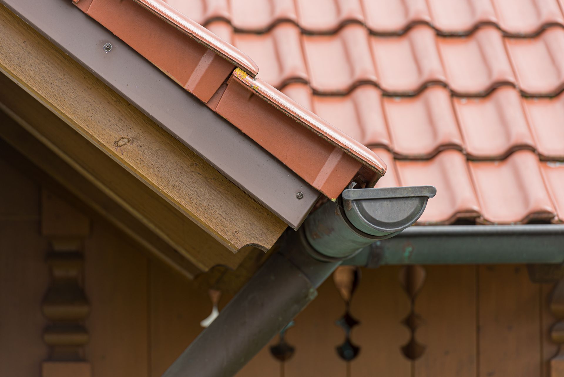 The corner of a grey gutter system on the edge of a modern home.