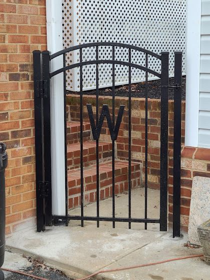 Black wrought iron gate with the letter 