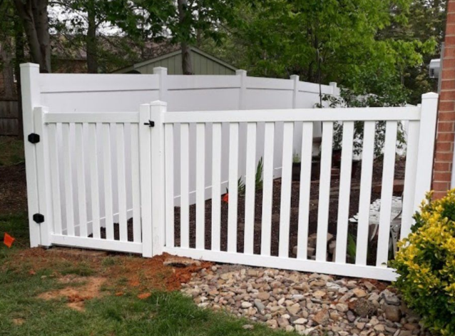 White picket fence with gate in a yard.