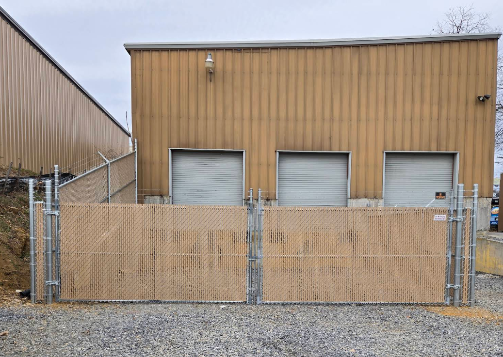 Commercial fence installation with privacy slats by a professional fence contractor in Boones Mill, securing a business loading dock area Commercial fence installation with privacy slats by a professional fence contractor in Boones Mill, securing a business loading dock area