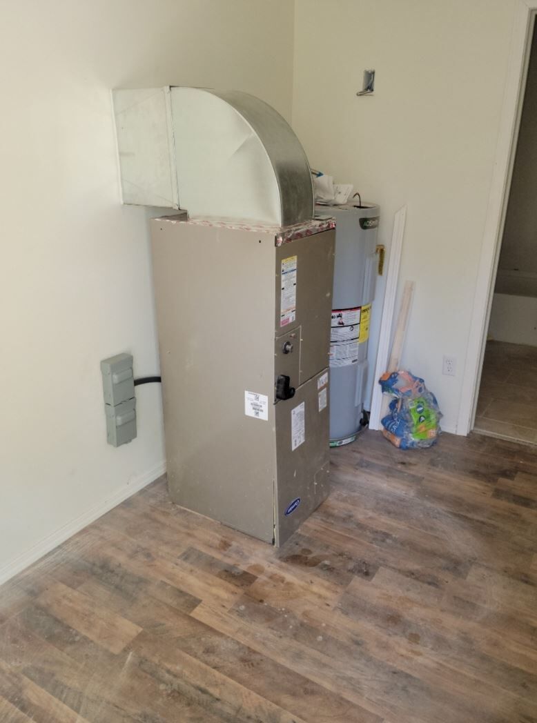 Brown cabinet with a curved white top stands in a sparse room with wood flooring.