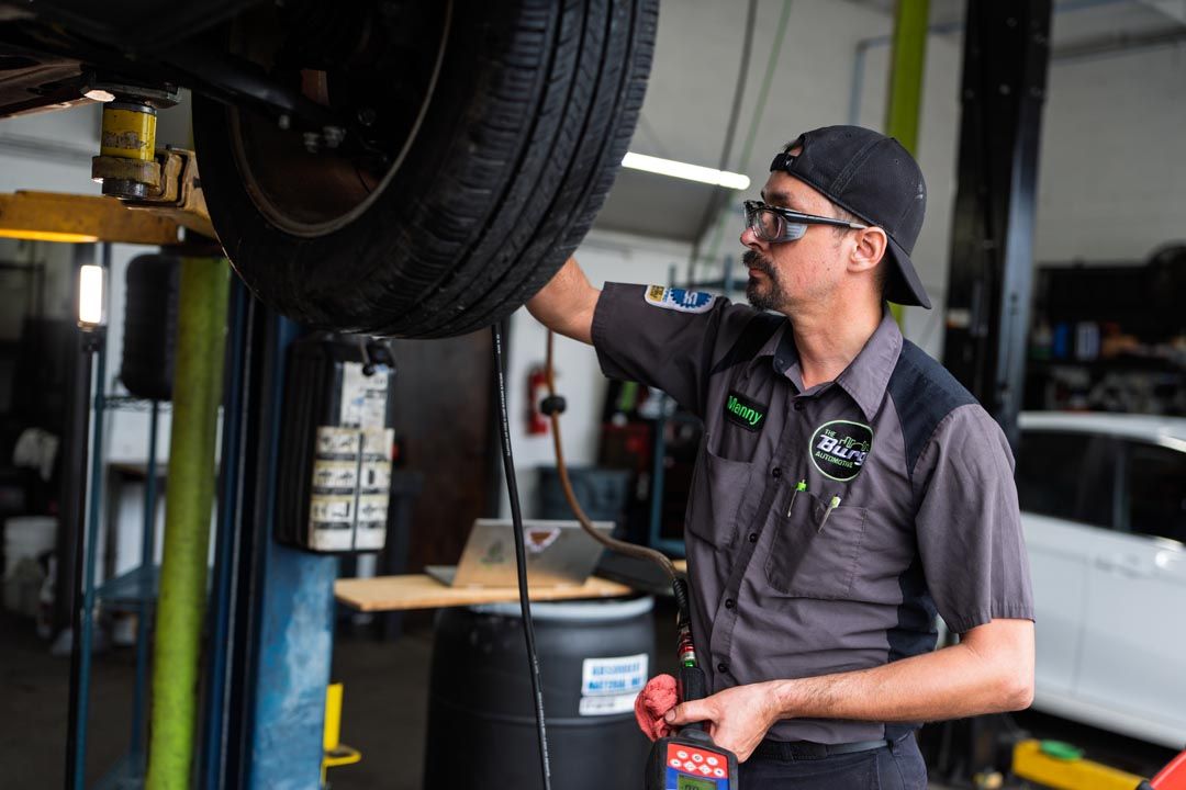 Mechanic inspecting a car on a lift in an auto repair shop