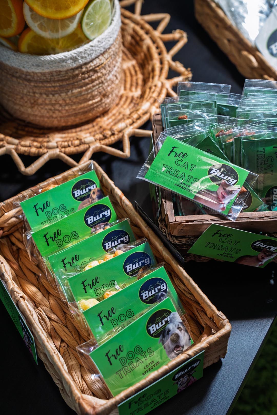 Green packaged snack bars in wicker baskets on a table, with a glass of citrus water nearby.