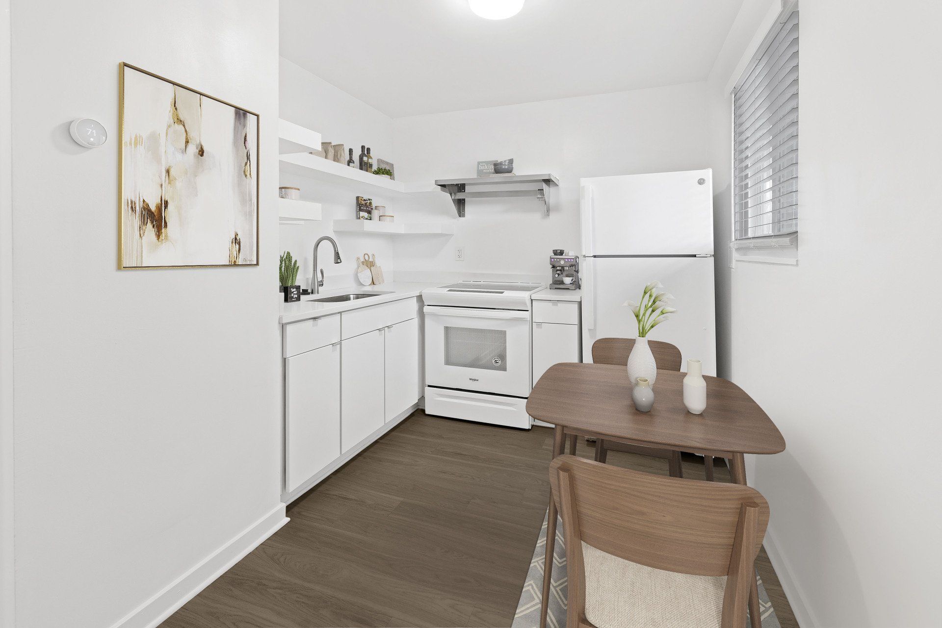 A kitchen with a table and chairs and a refrigerator.