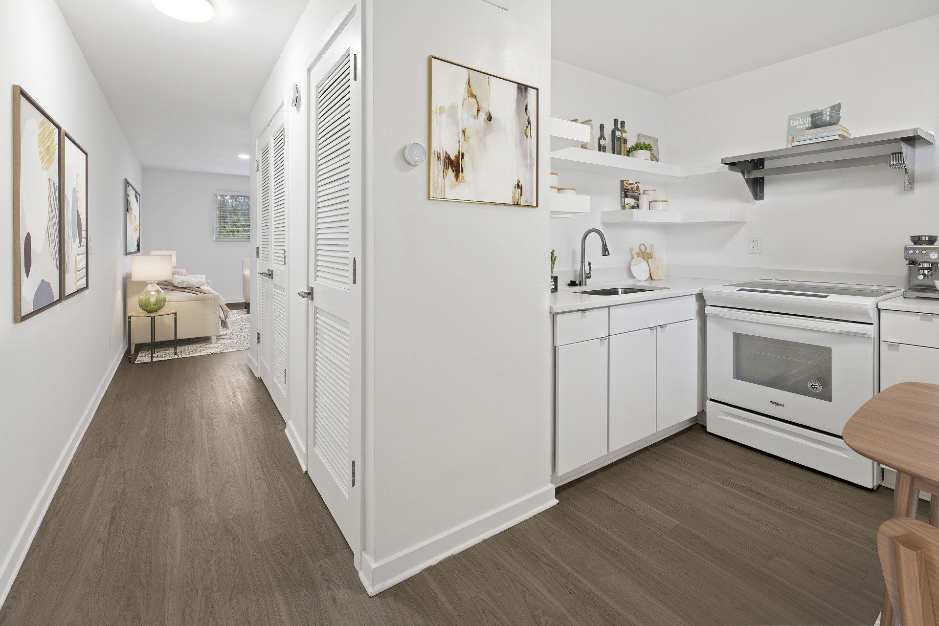 A kitchen with white cabinets , a stove , and a sink.