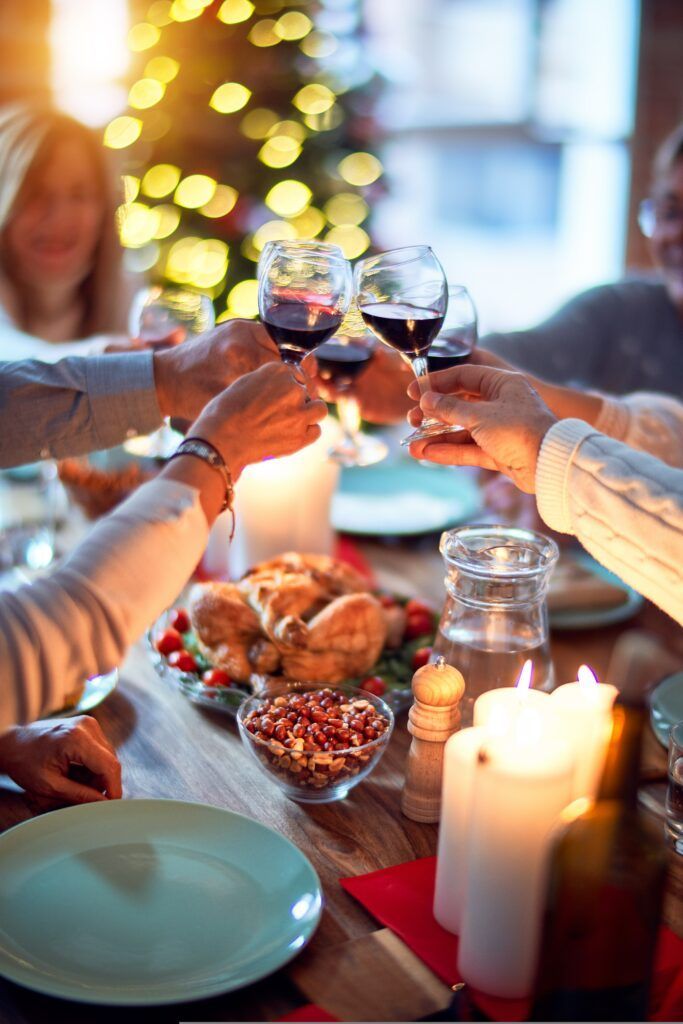 family celebrates the holidays by toasting with wine glasses