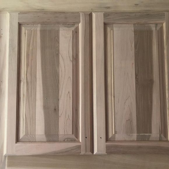 Two unfinished wooden cabinet doors featuring vertical slats with contrasting light and dark natural wood grain.