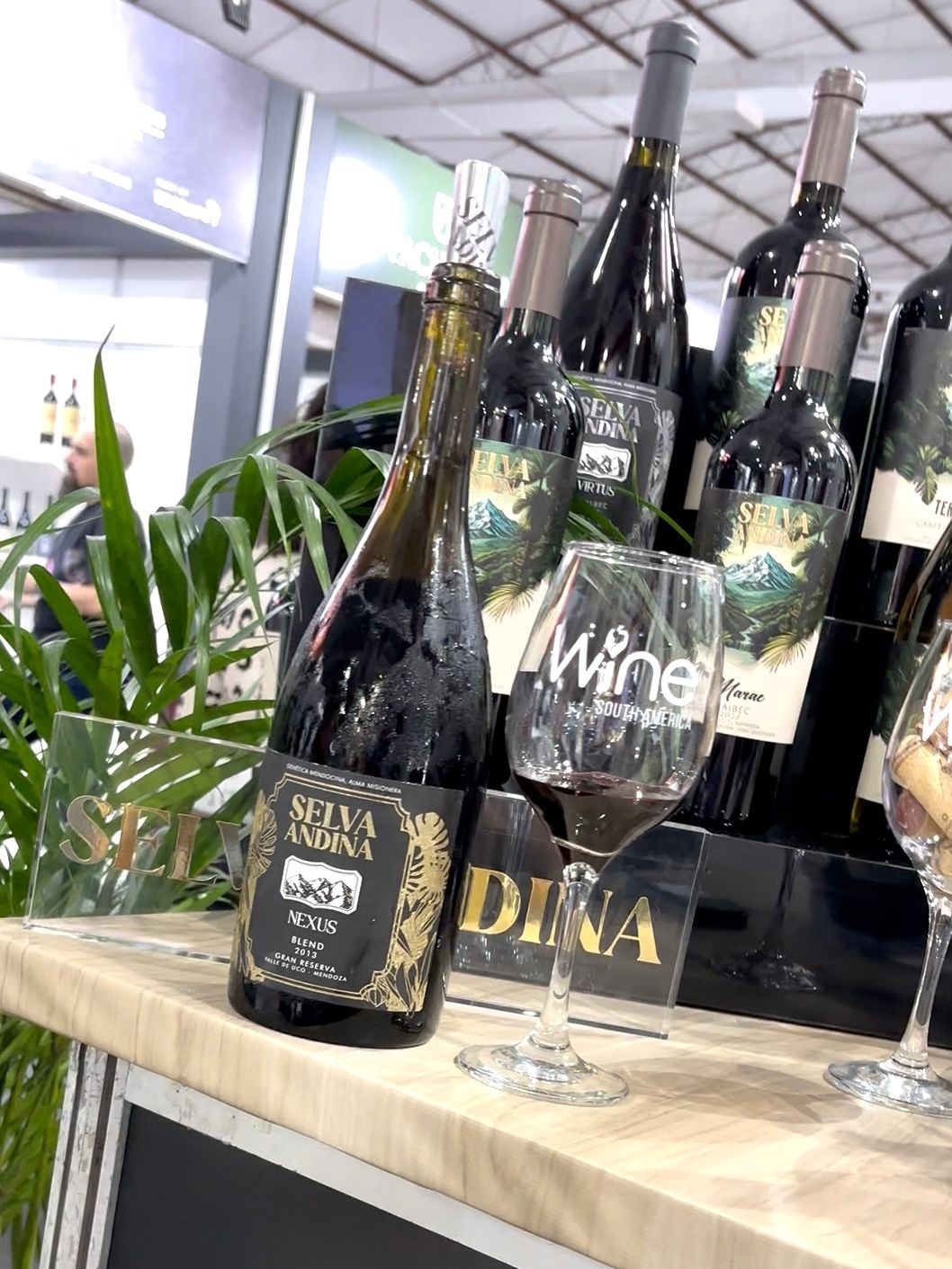 Botellas de vino y una copa expuestas en un evento.