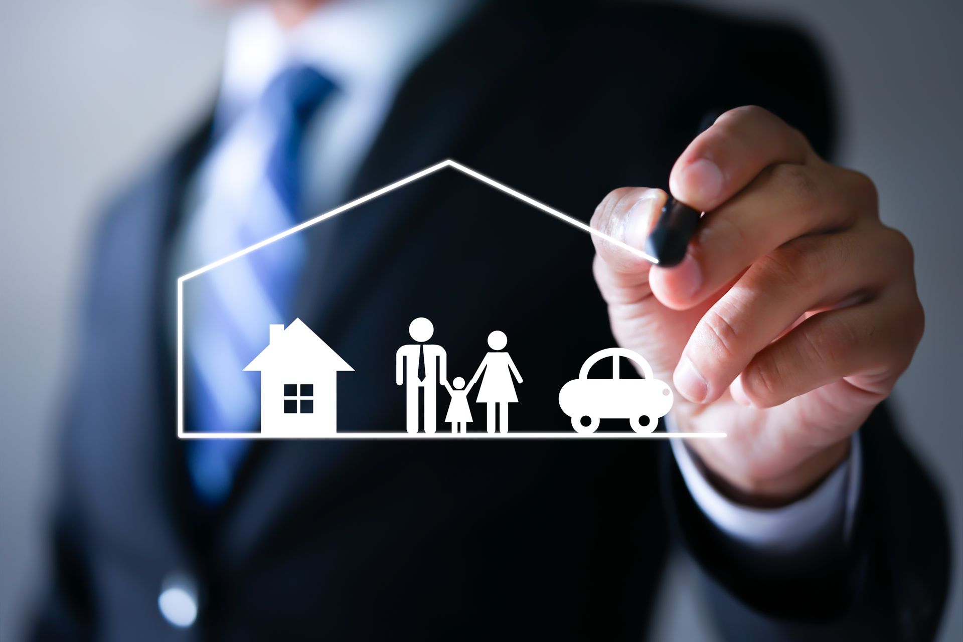 Hand in suit drawing a white house, family, and car outline on glass