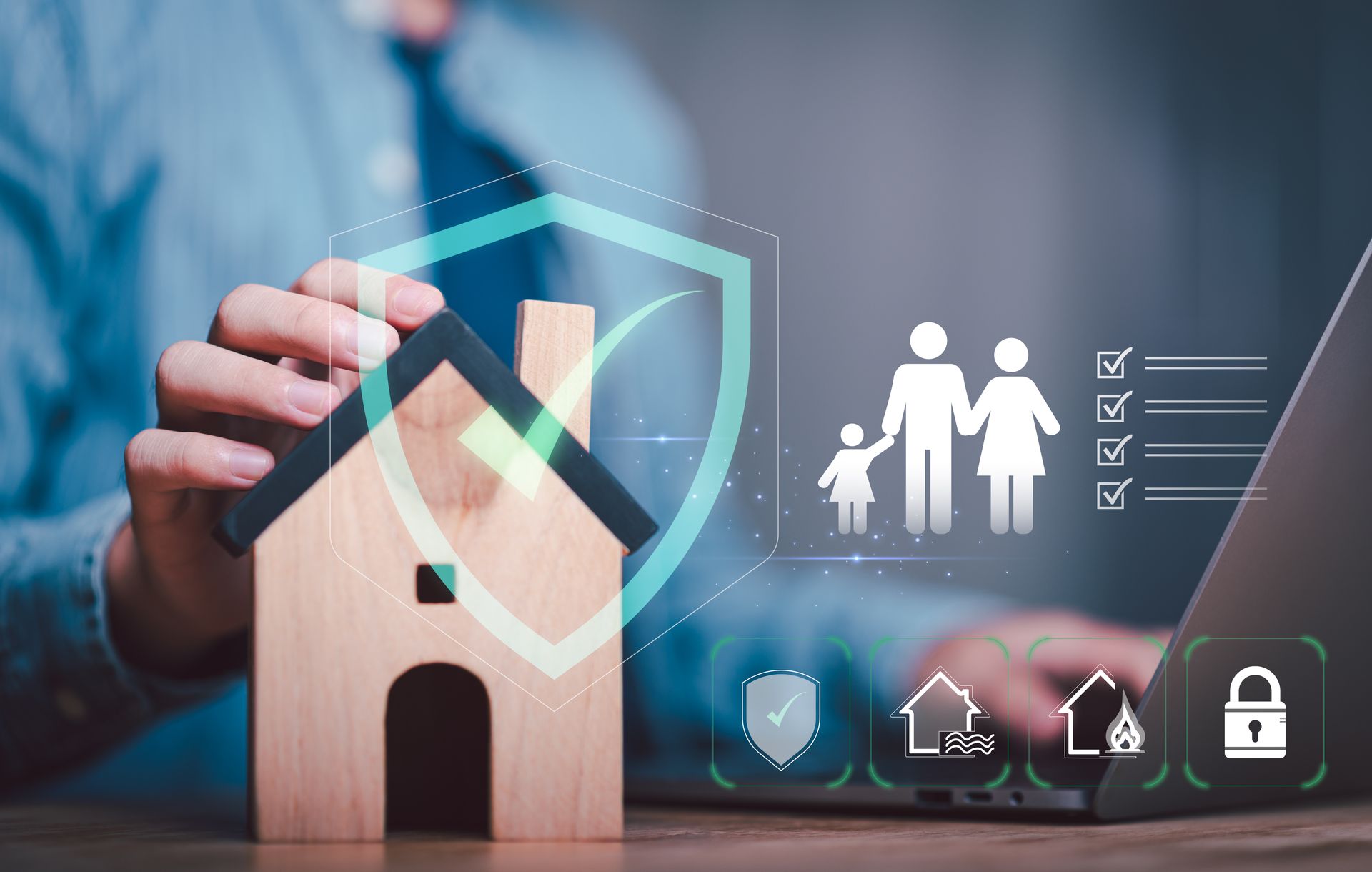 Hand placing wooden house beside glowing shield and security icons on a laptop screen