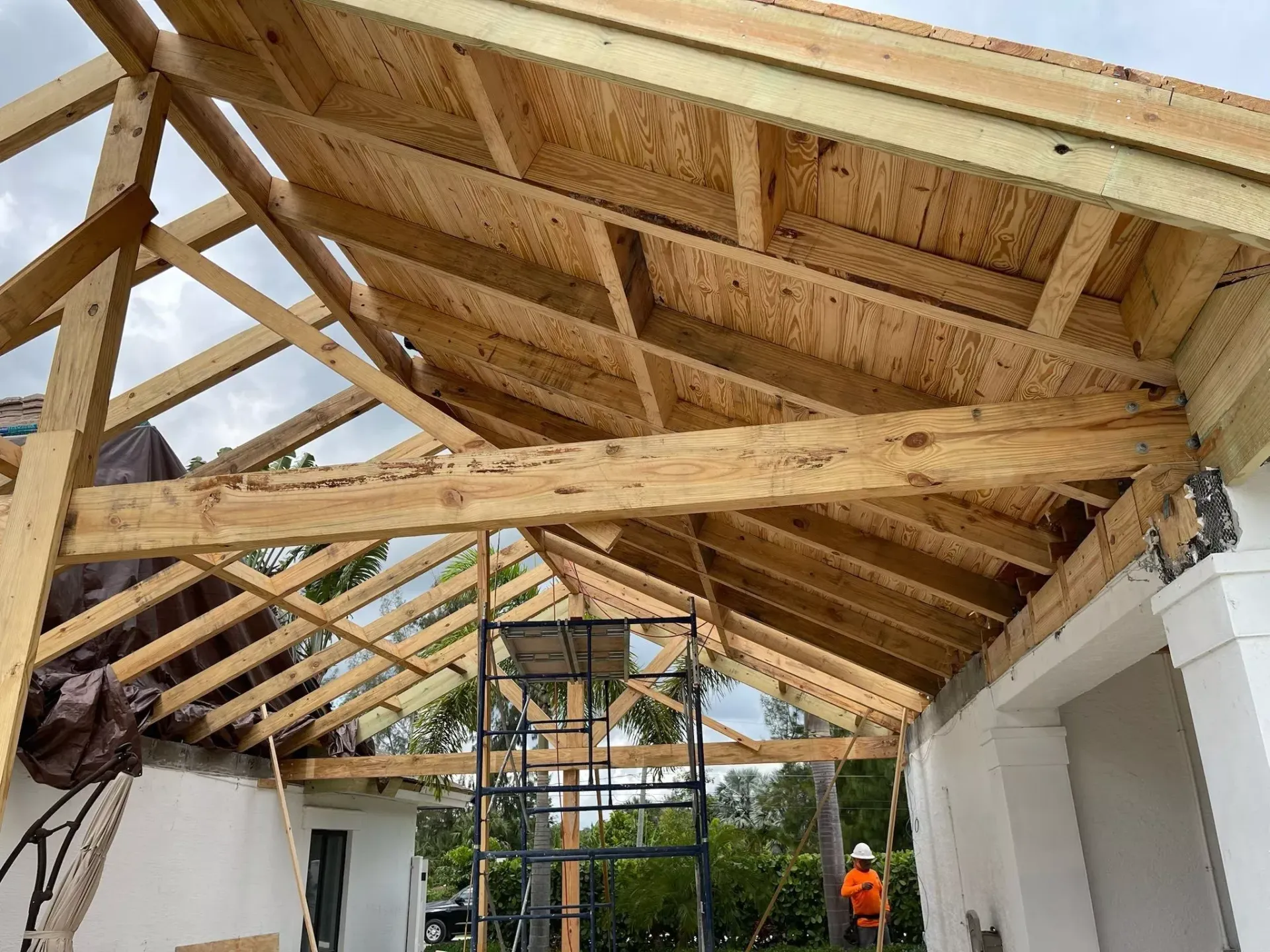 A wooden structure is being built on top of a white building.