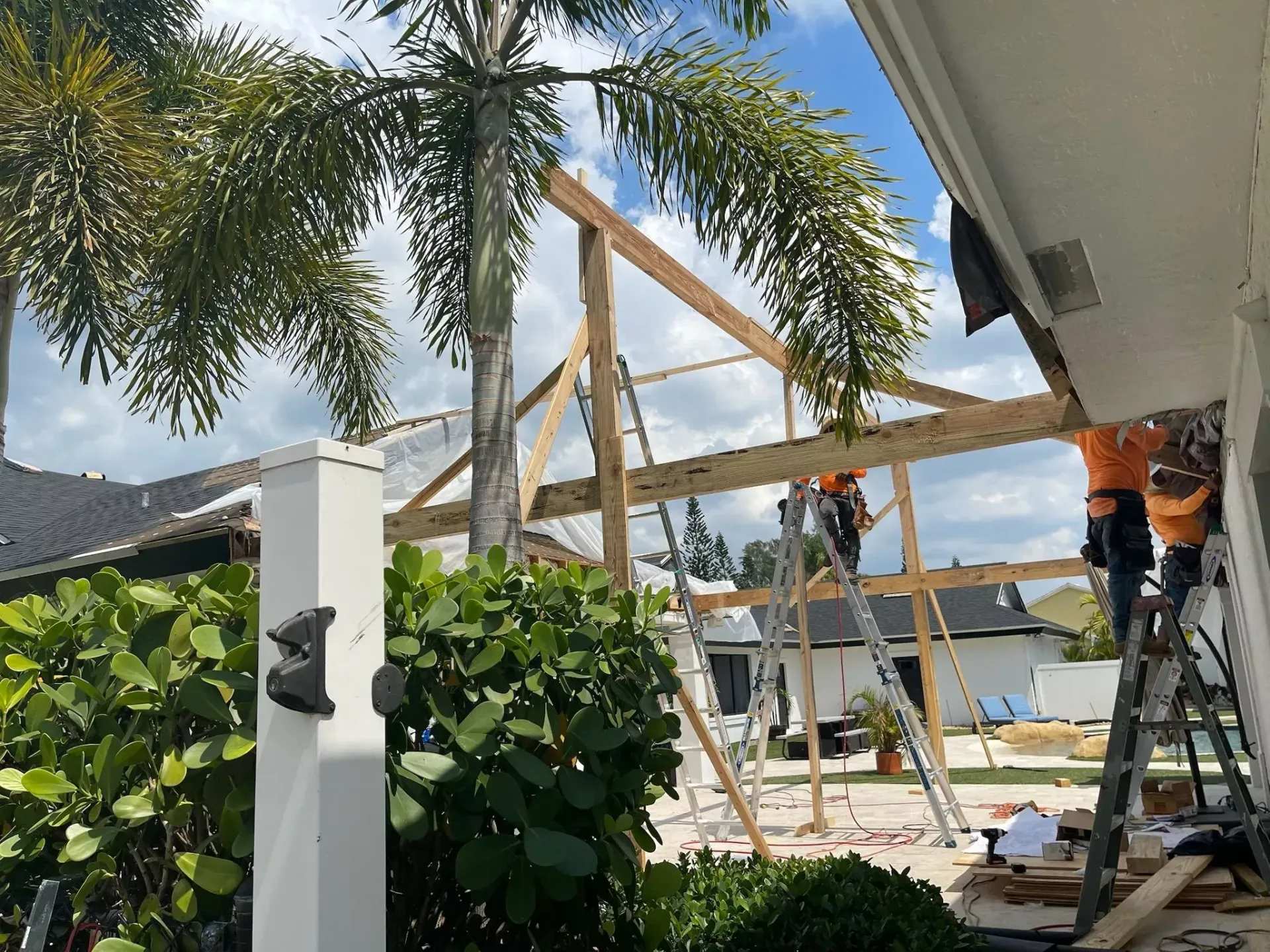 A group of construction workers are working on a house.