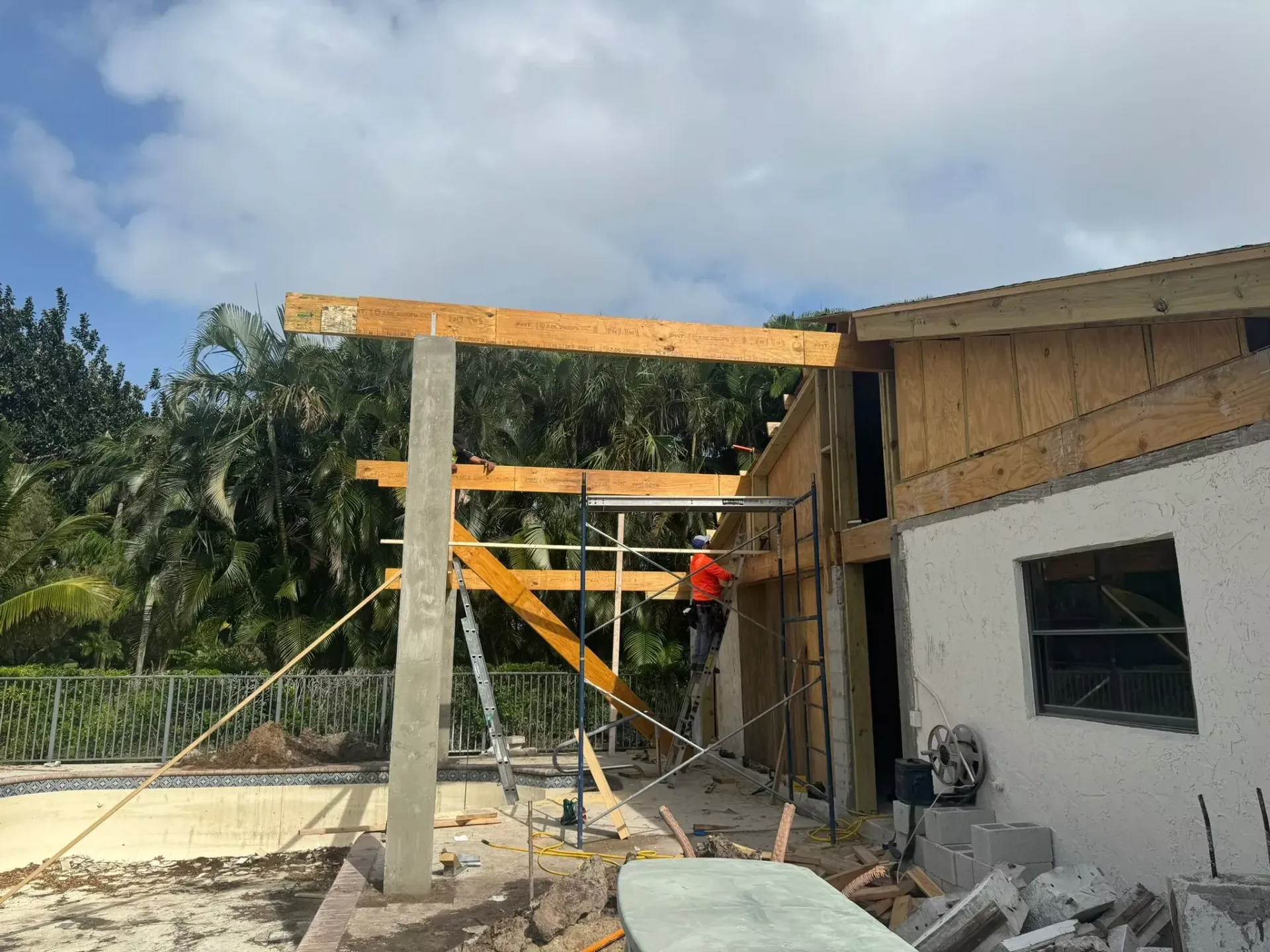 A house is being built with wooden beams and scaffolding.