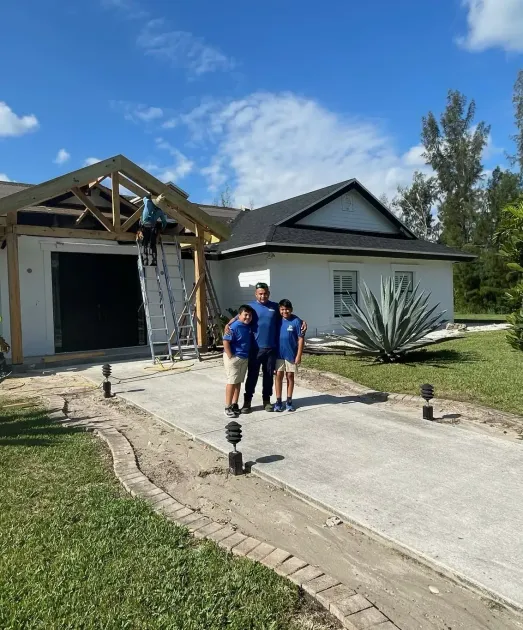 A group of people are standing in front of a house under construction.