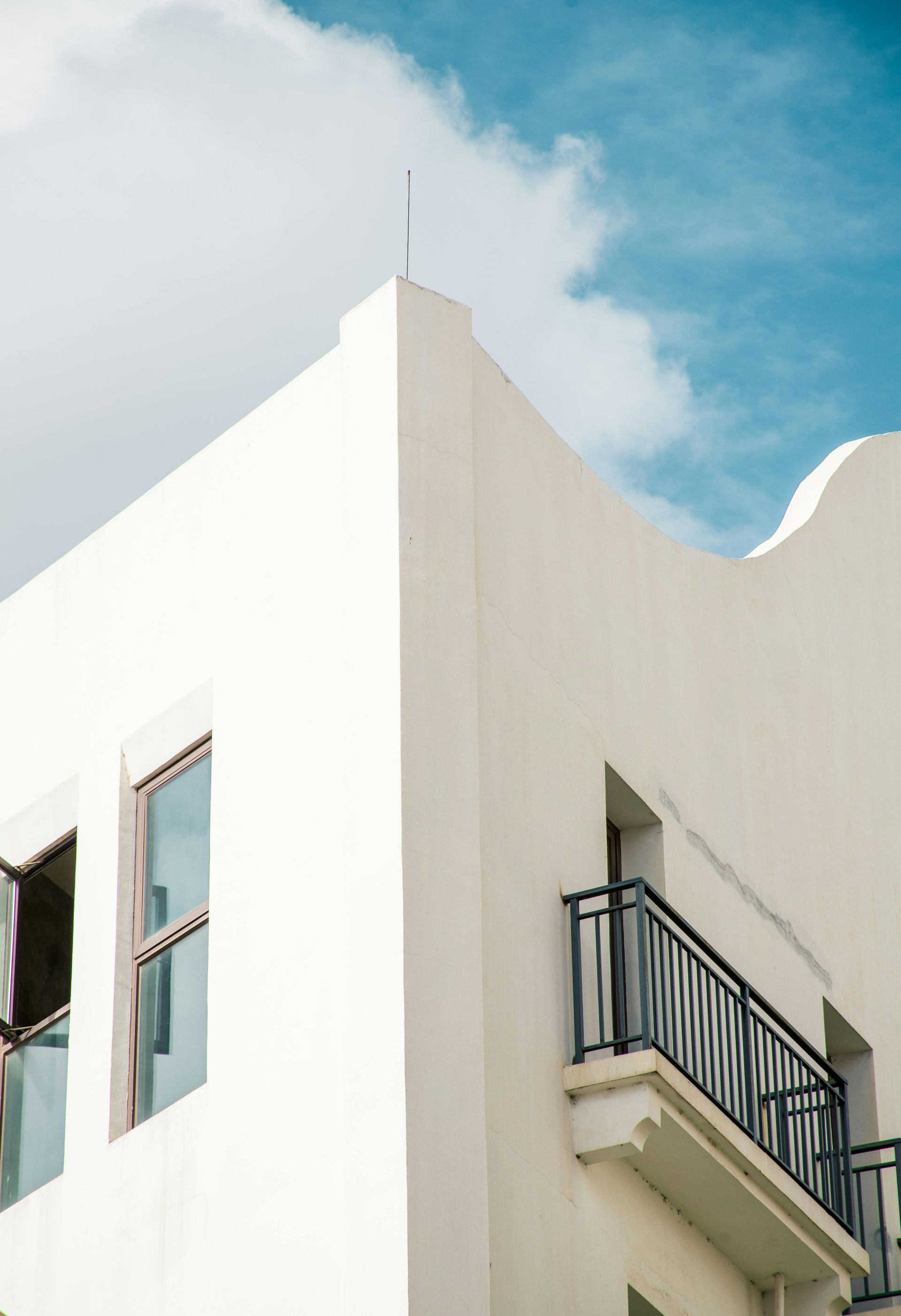 A white van is parked in front of a house under construction.