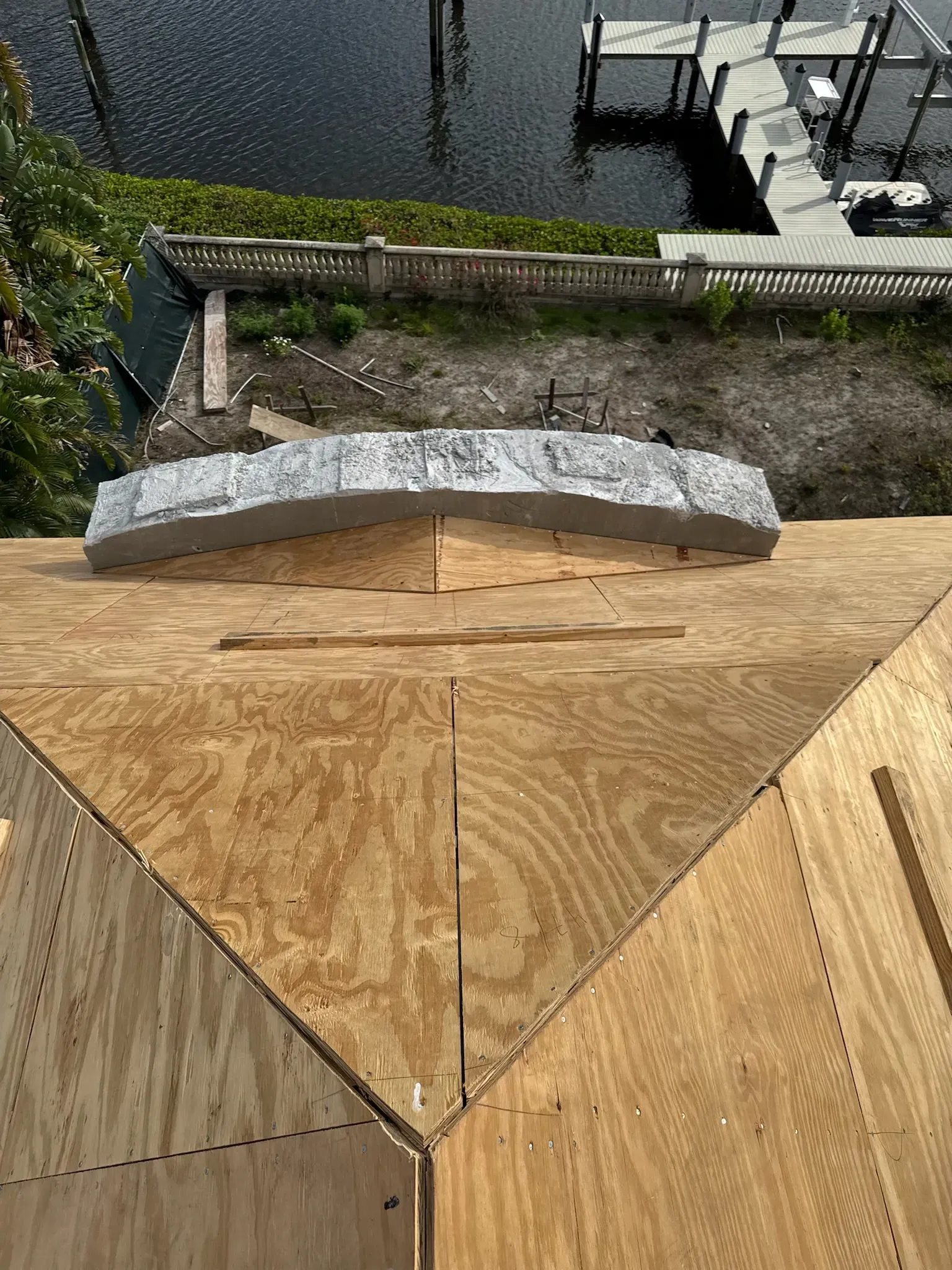 A wooden roof with a dock in the background is being built.