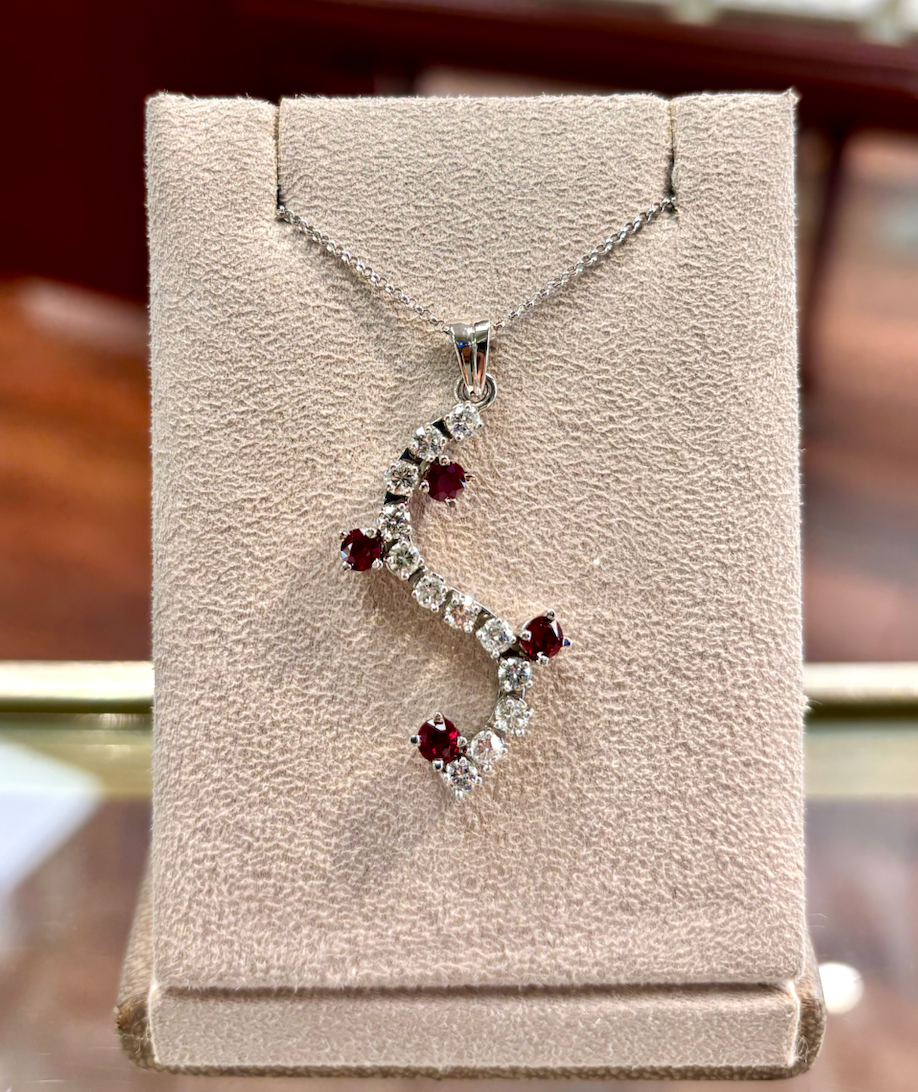 A necklace is displayed on a mannequin in a jewelry store.