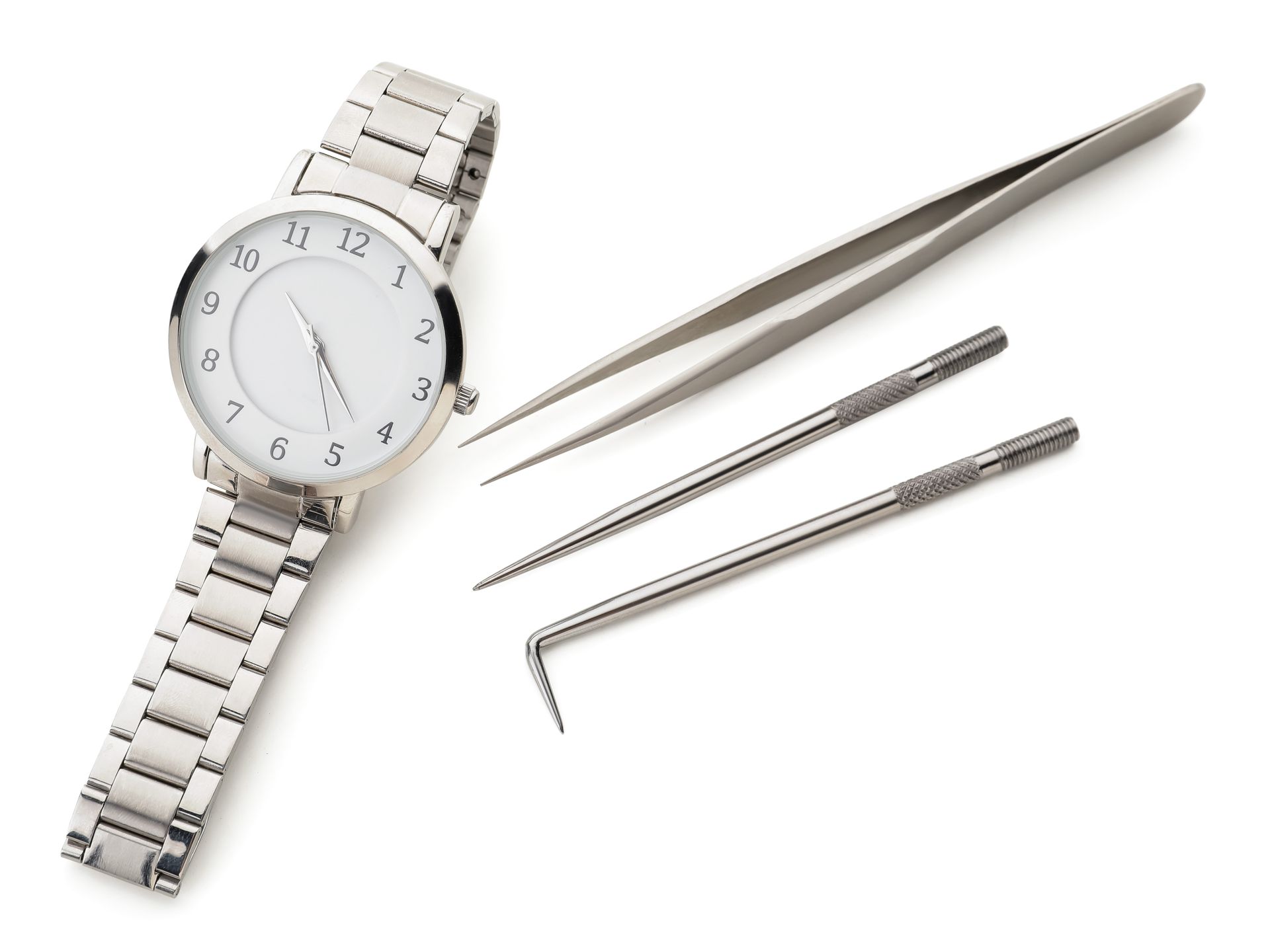 Silver wristwatch with tweezers and two small watch repair tools on a white background