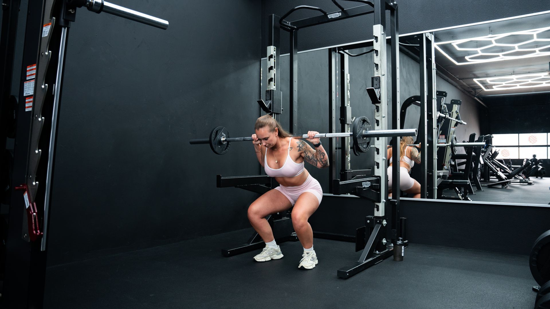 Twee vrouwen doen sit-ups op een yogamat in een sportschool.