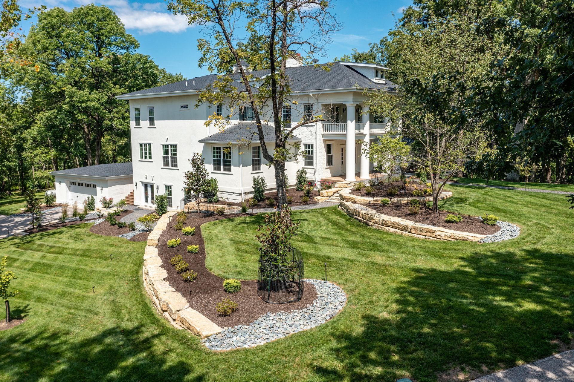 A large white house with a lush green lawn in front of it.