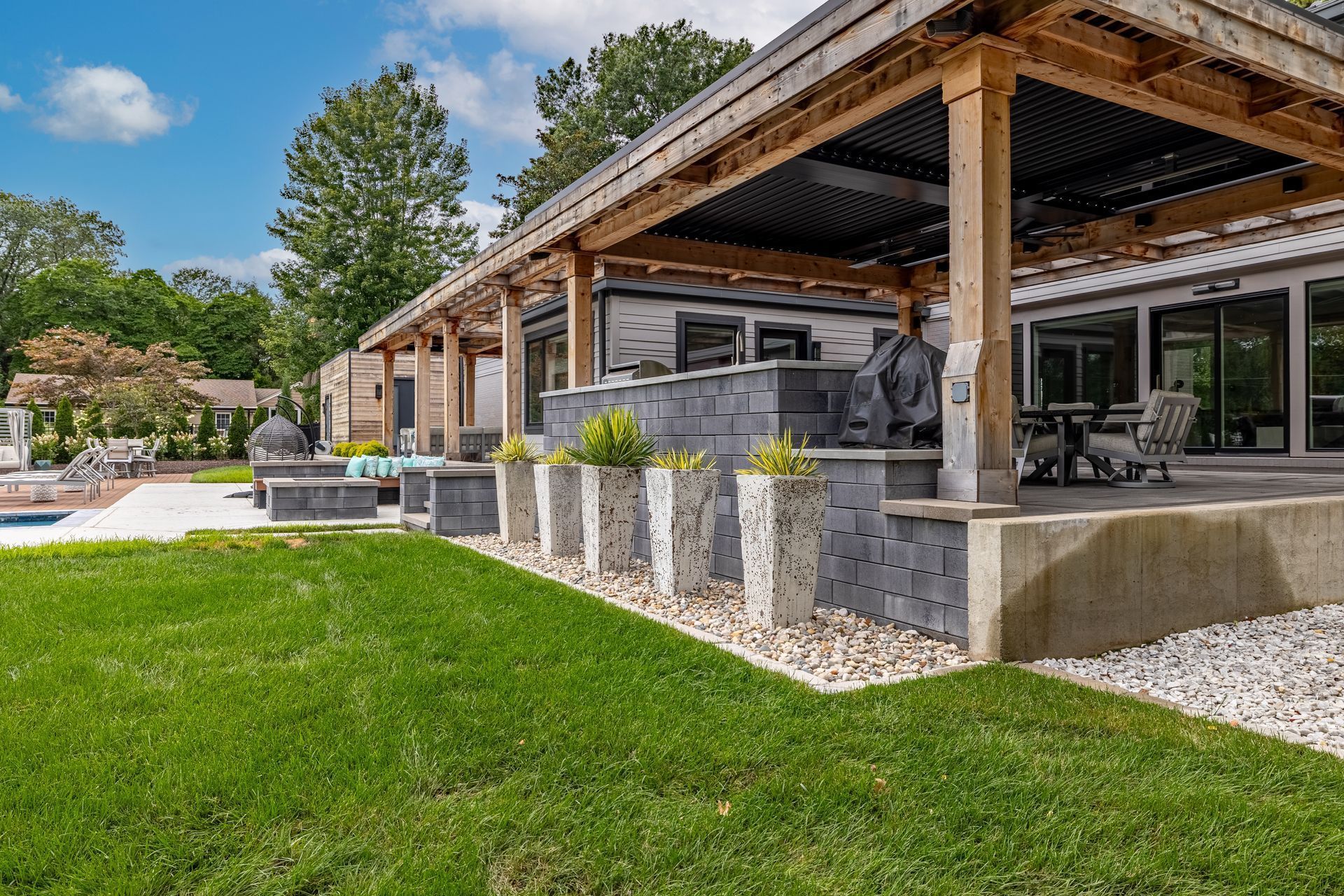 A large house with a covered patio and a swimming pool in the backyard.