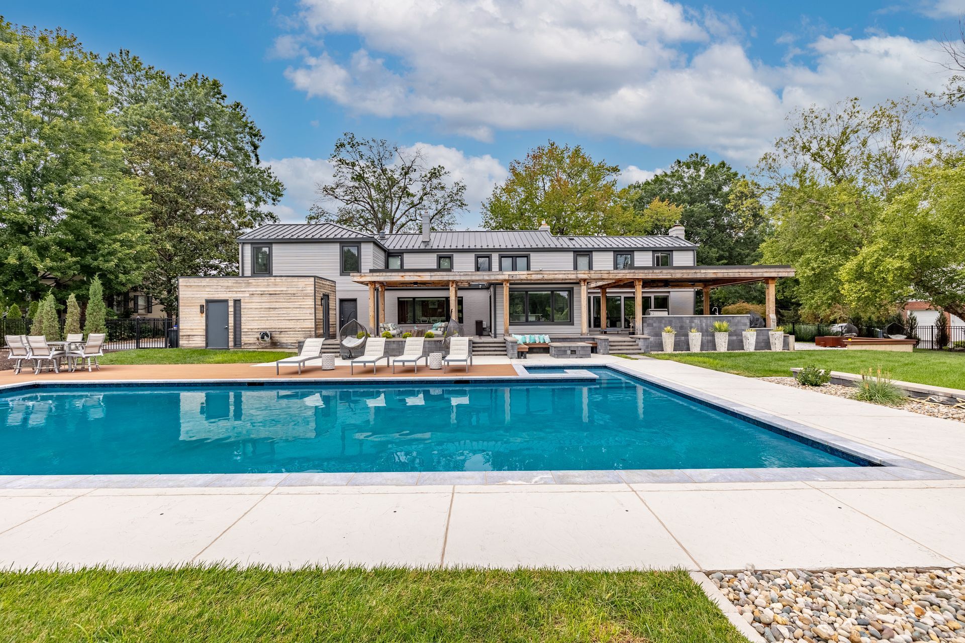 A large house with a large swimming pool in front of it.