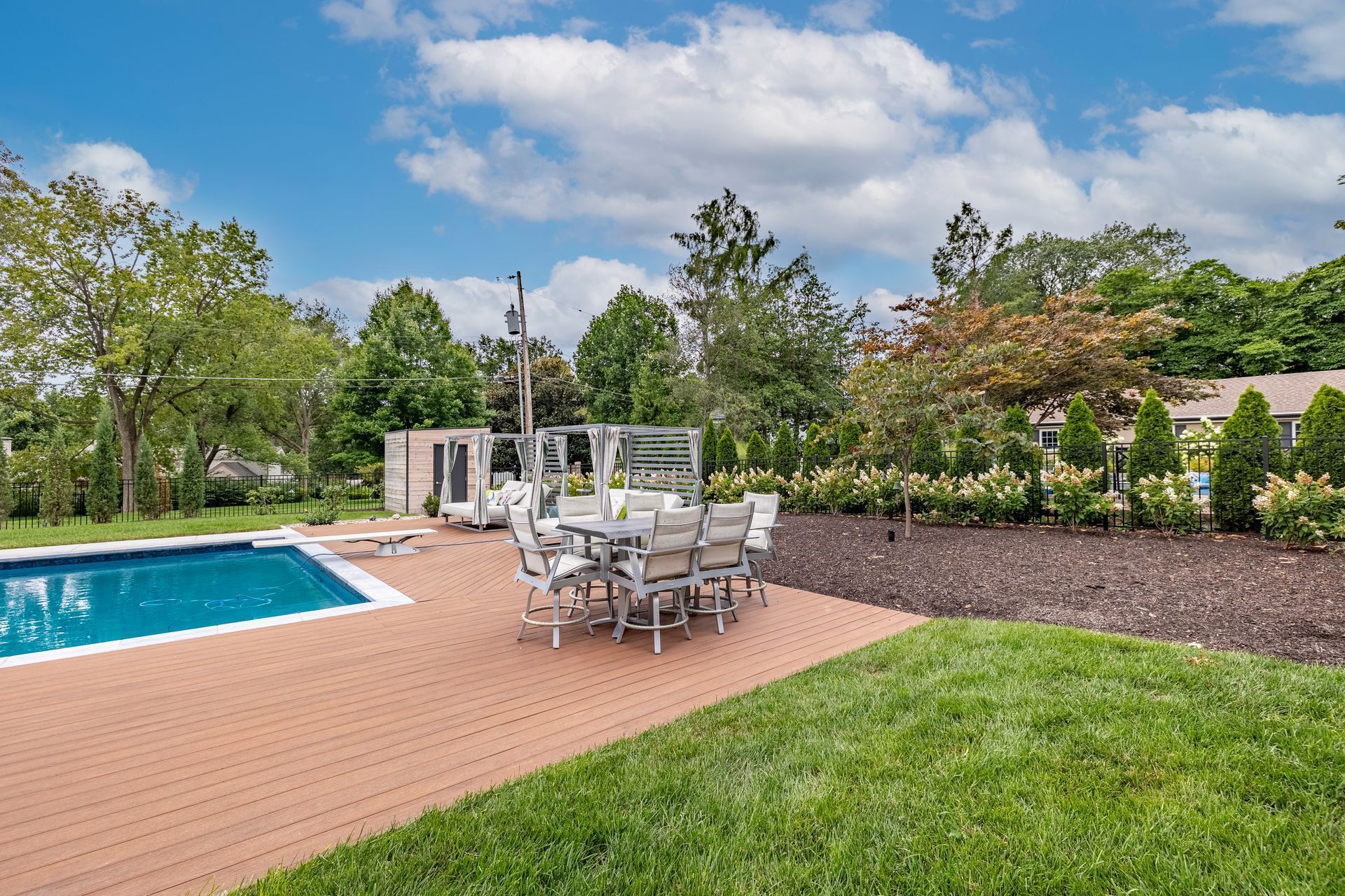 A large swimming pool with a table and chairs in front of it