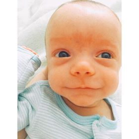 a close up of a baby wearing a blue and white striped shirt .